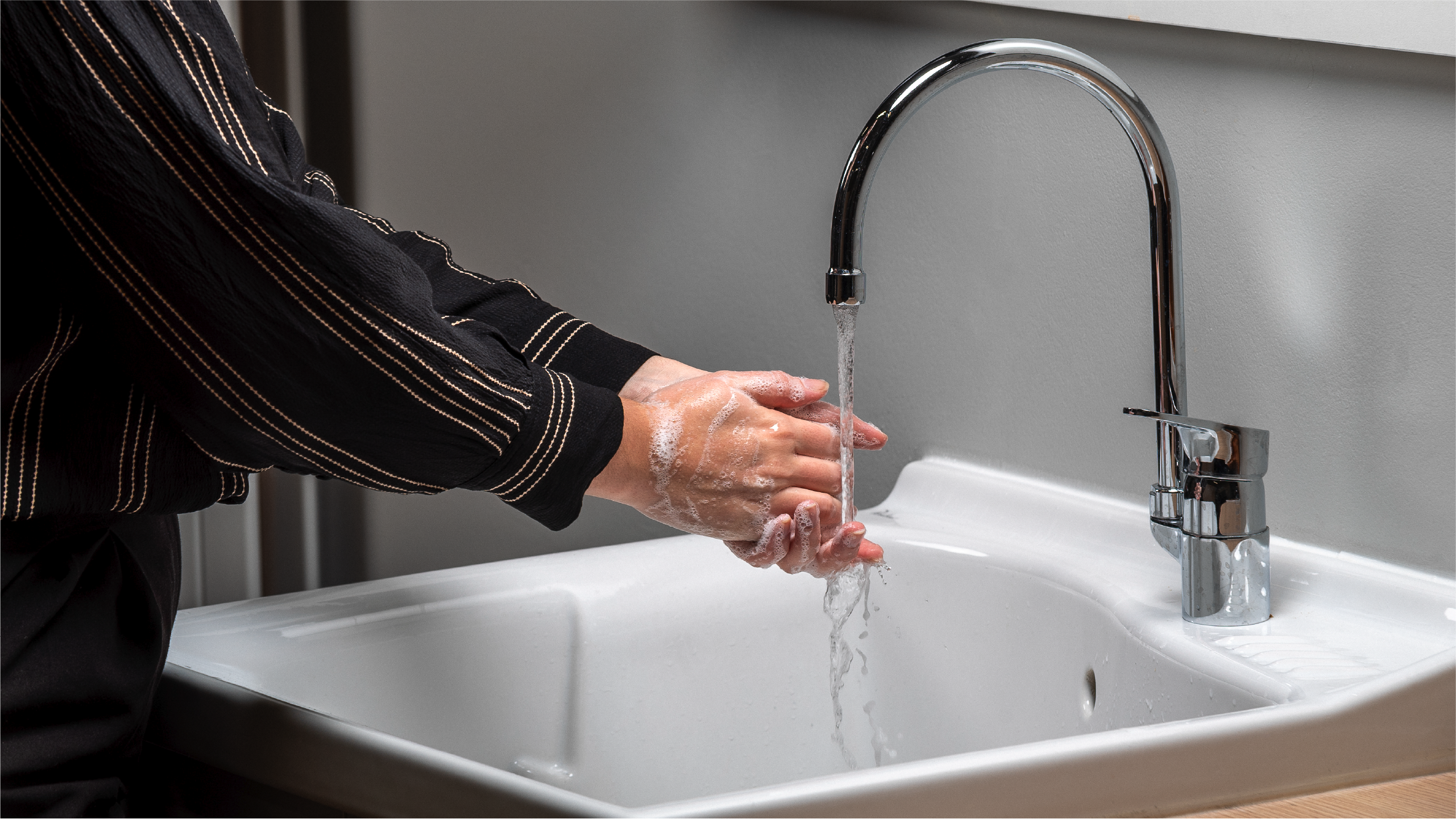 women doing hand hygenie a bathroom