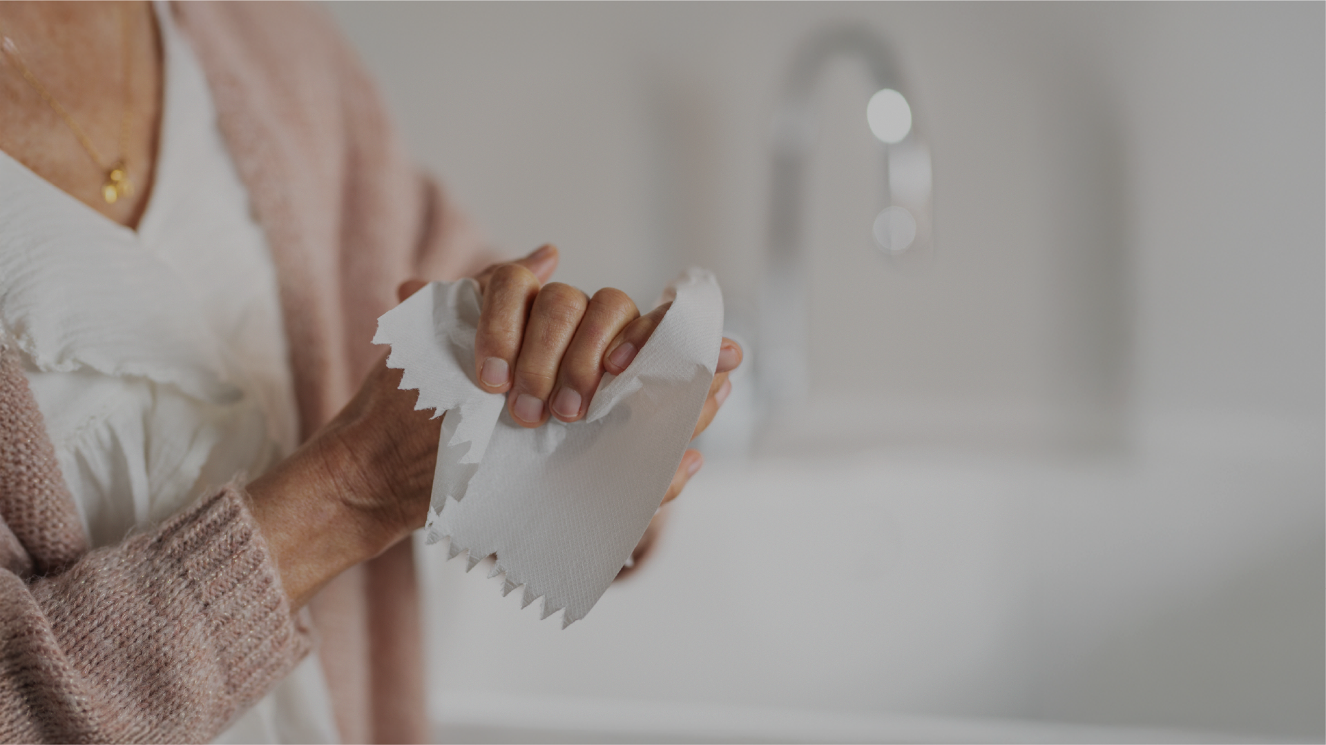 a woman dries her hands in a modern bathroom